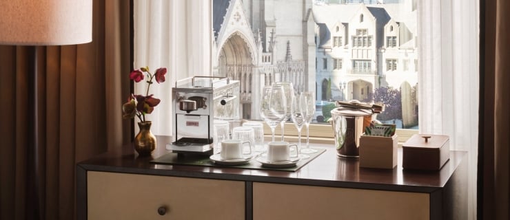 A chest of drawers with minibar, espresso machine and mini fridge overlooking the cathedral