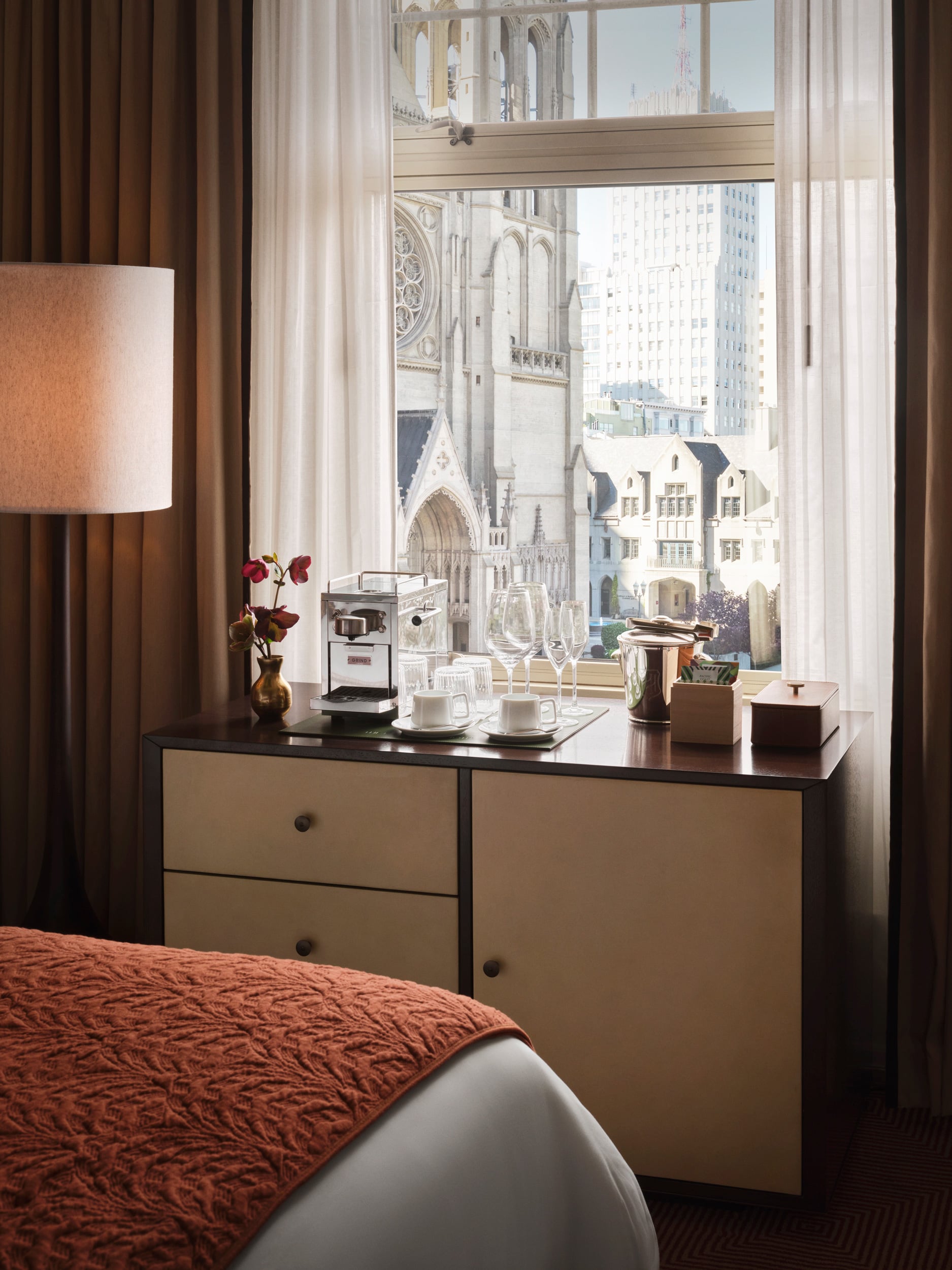 A chest of drawers with minibar, espresso machine and mini fridge overlooking the cathedral