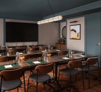 A blue ceiling, gray wall room with warm carpeting and tables set up for a meeting.