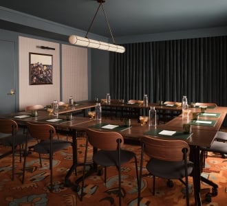 A professionally styled conference room features dark slate-blue walls and a matching ceiling, with a large square shaped wooden meeting table