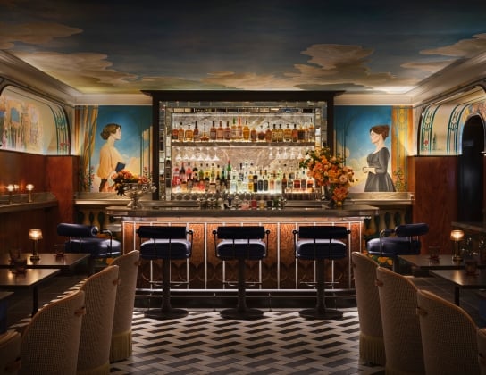 A warm wood bar with tile floor and a mural on the ceiling and walls